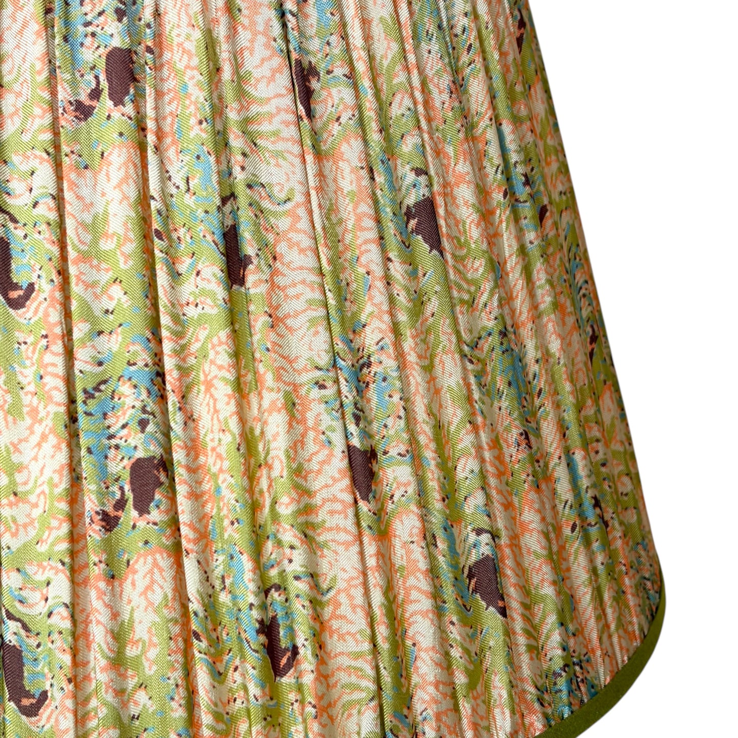 A close-up of a gathered silk lampshade featuring a vintage coral and seaweed botanical pattern with green leaves, peach and pink flowers finished with olive green trim at the top bottom.
