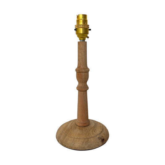 A small mango woode table lamp base with a turned natural oak finish and a brass socket at the top, isolated on a white background.