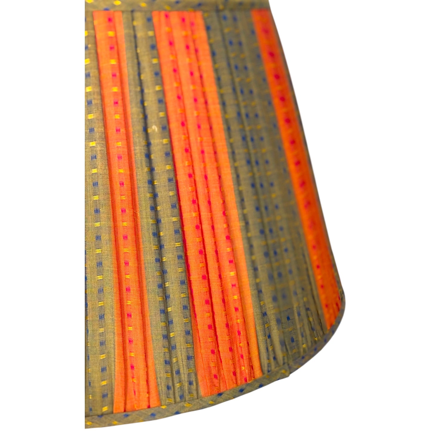 A close-up of the gathered cotton fabric lampshade featuring vertical stripes of orange and green with small yellow, blue and red dotted accents, shown against a plain white background.