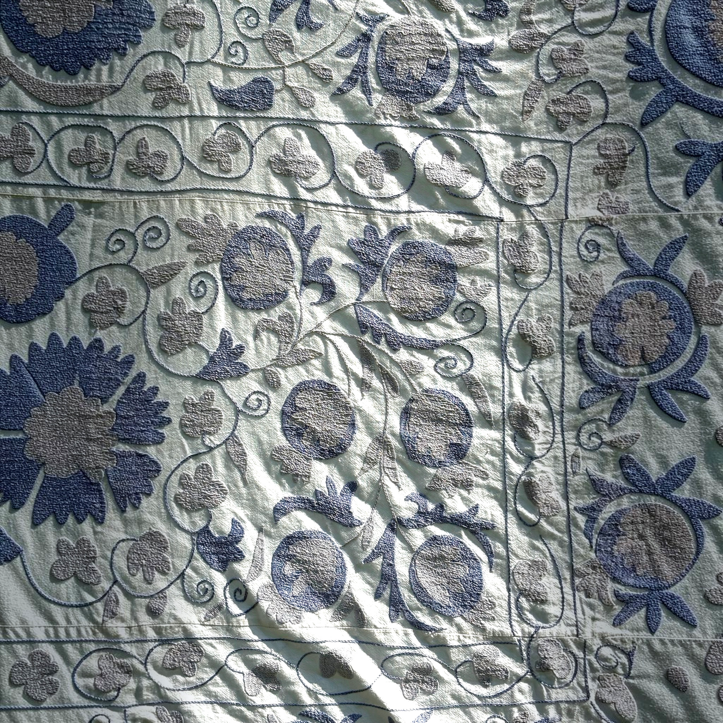 A closer look at the embroidery of the pale blue Suzani.