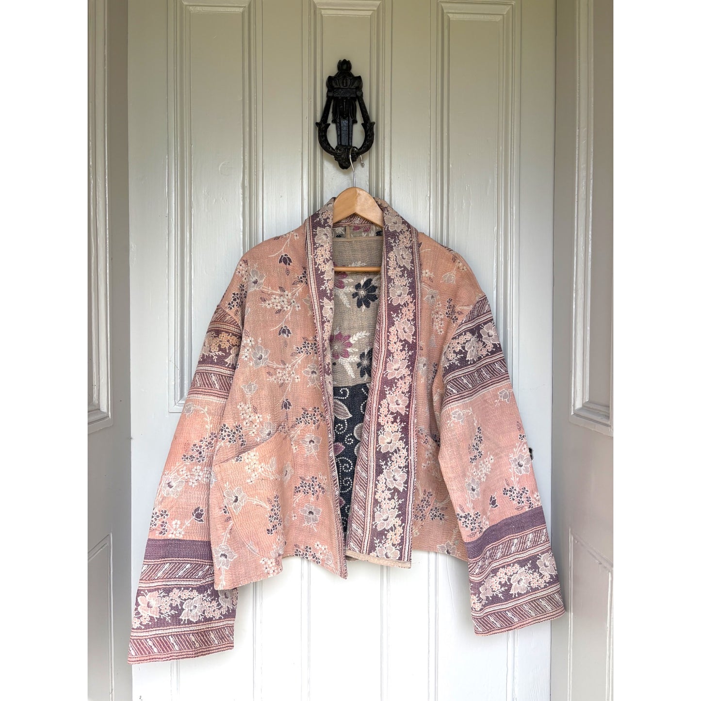 pale pink and aubergine kantha coat on door