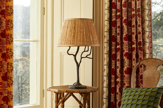 Shibori lampshade on a metal tree lamp base in the window on a table