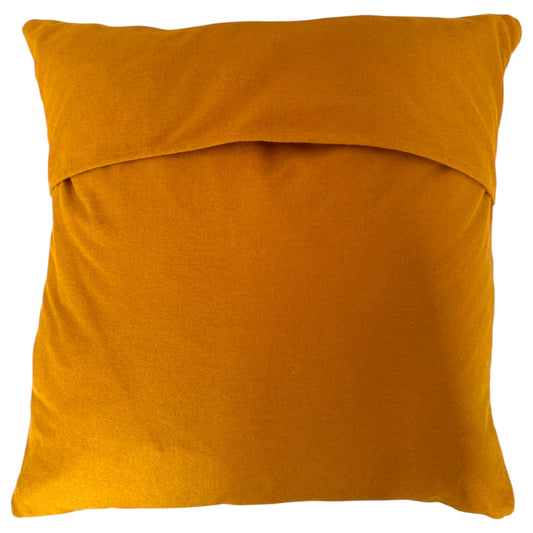 Back view of the square Banjara cushion showing turmeric natural fabric with a folded top edge, shown against a plain white background.