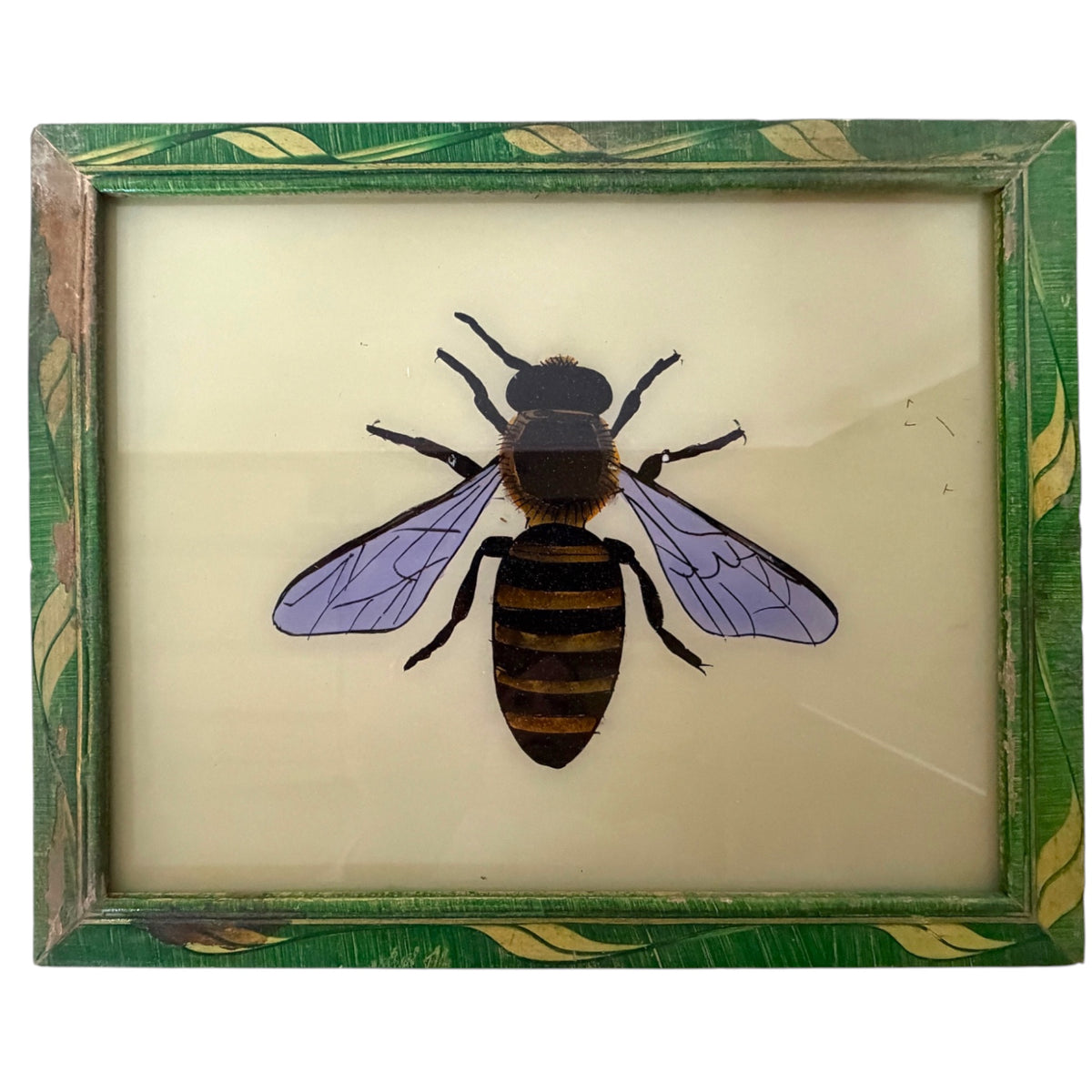 A framed vintage insect specimen featuring a painted bee on a cream-colored backing, surrounded by a distressed green and gold leaf-patterned frame.