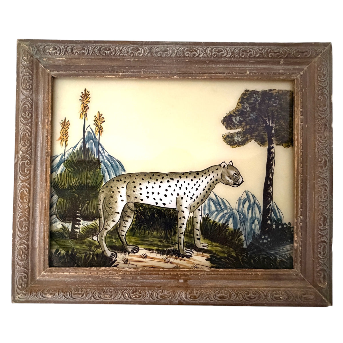 Hand-painted spotted cheetah in a landscape with trees and blue hills, reverse glass painting in a carved wooden frame