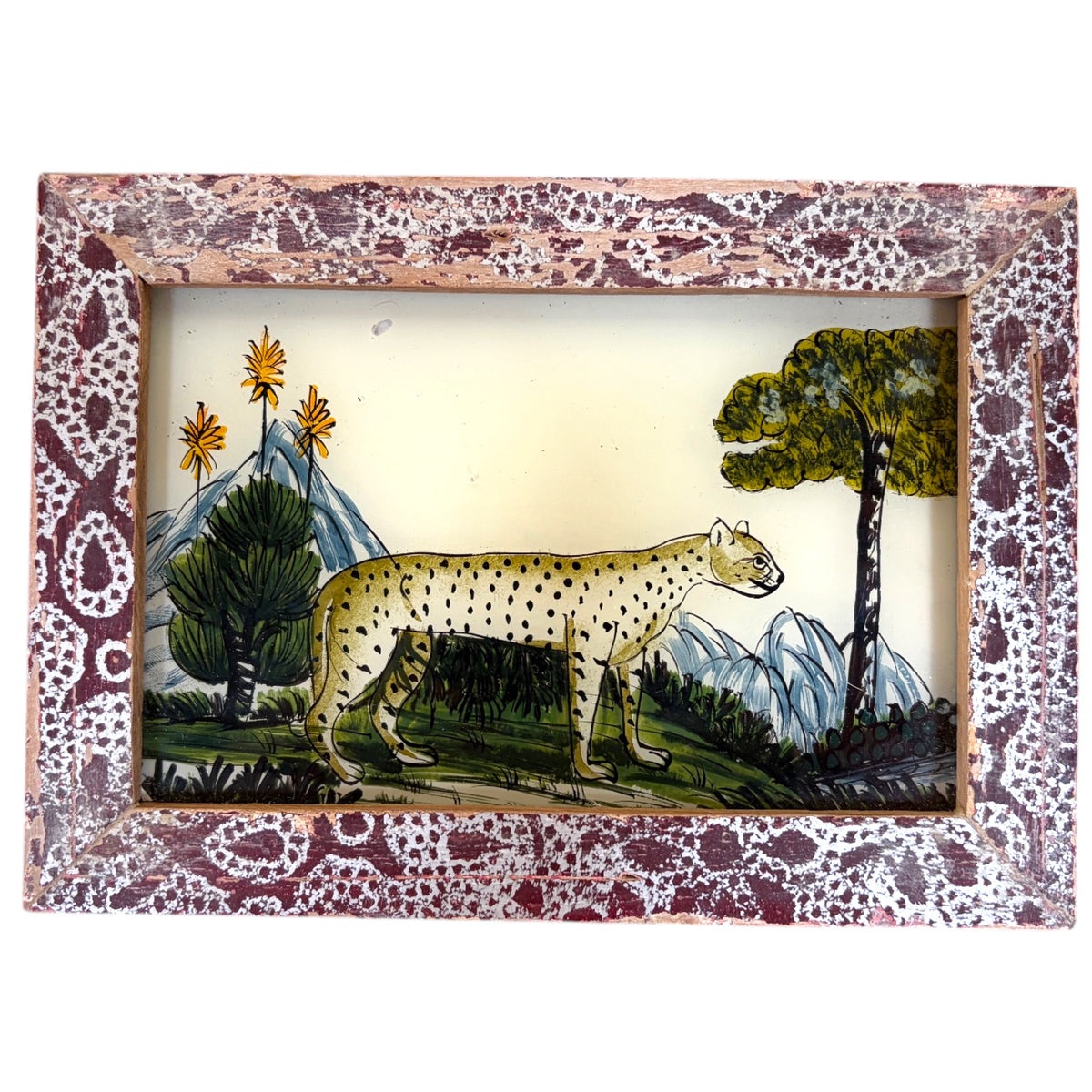 a spotted cheetah prowling through a landscape of trees, blue mountains and golden aloe flowers. Burgundy frame with a white paisley pattern