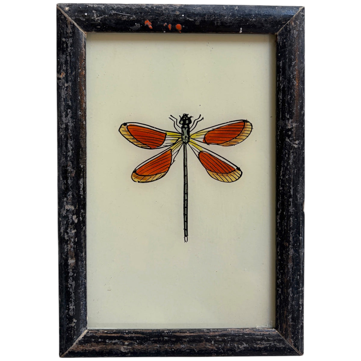 Framed wall art featuring a stylized dragonfly illustration with orange-red wings on a cream background, set in a distressed dark wood frame.