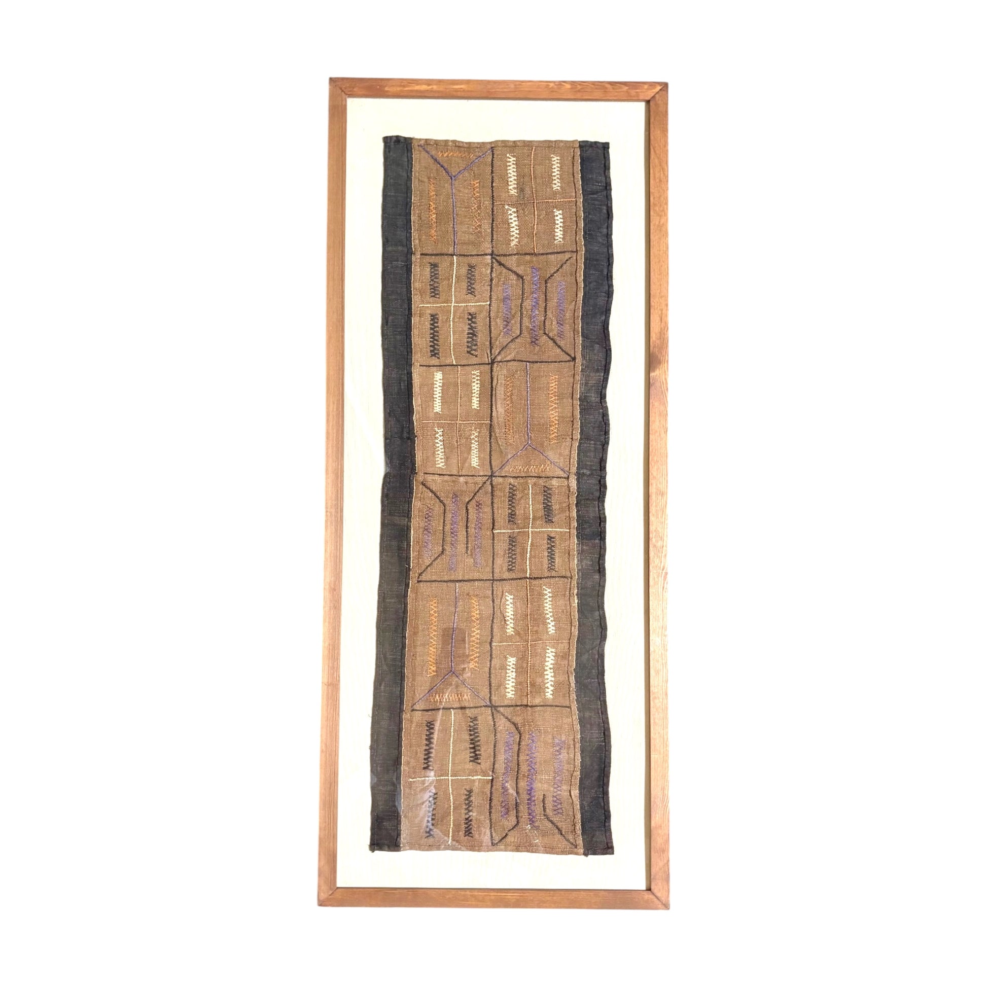 A framed African tribal textile runner with geometric patterns, featuring a natural brown woven body, dark brown side borders, and a light wood frame on a white background.