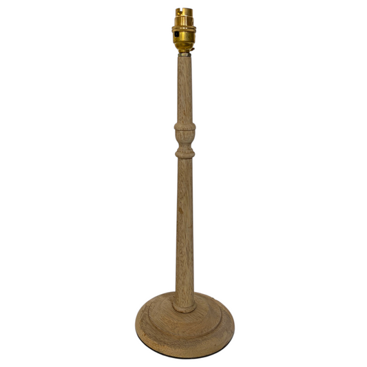 A candlestick mango wood table lamp with a tall, turned wood stem and a round base, featuring a brass-colored socket at the top, shown against a plain white background.