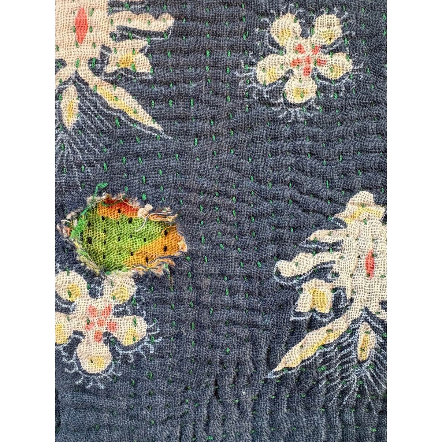 Close up of hole in blue and pink kantha quilt