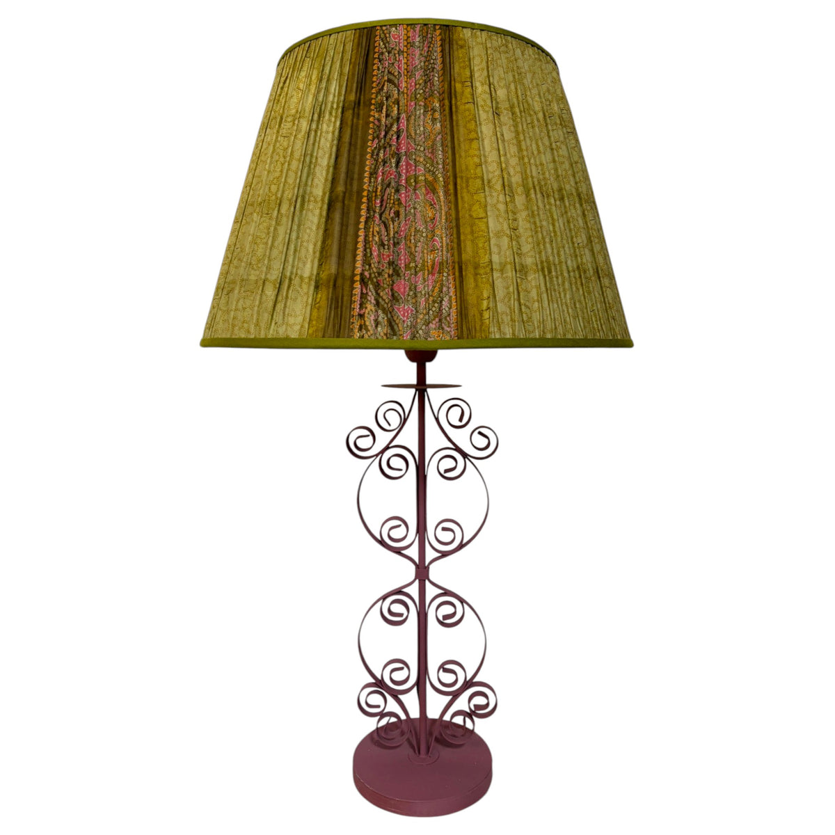 Olive green gathered silk sari lampshade with a central pink and orange paisley panel on a dusty pink scrolled iron table lamp