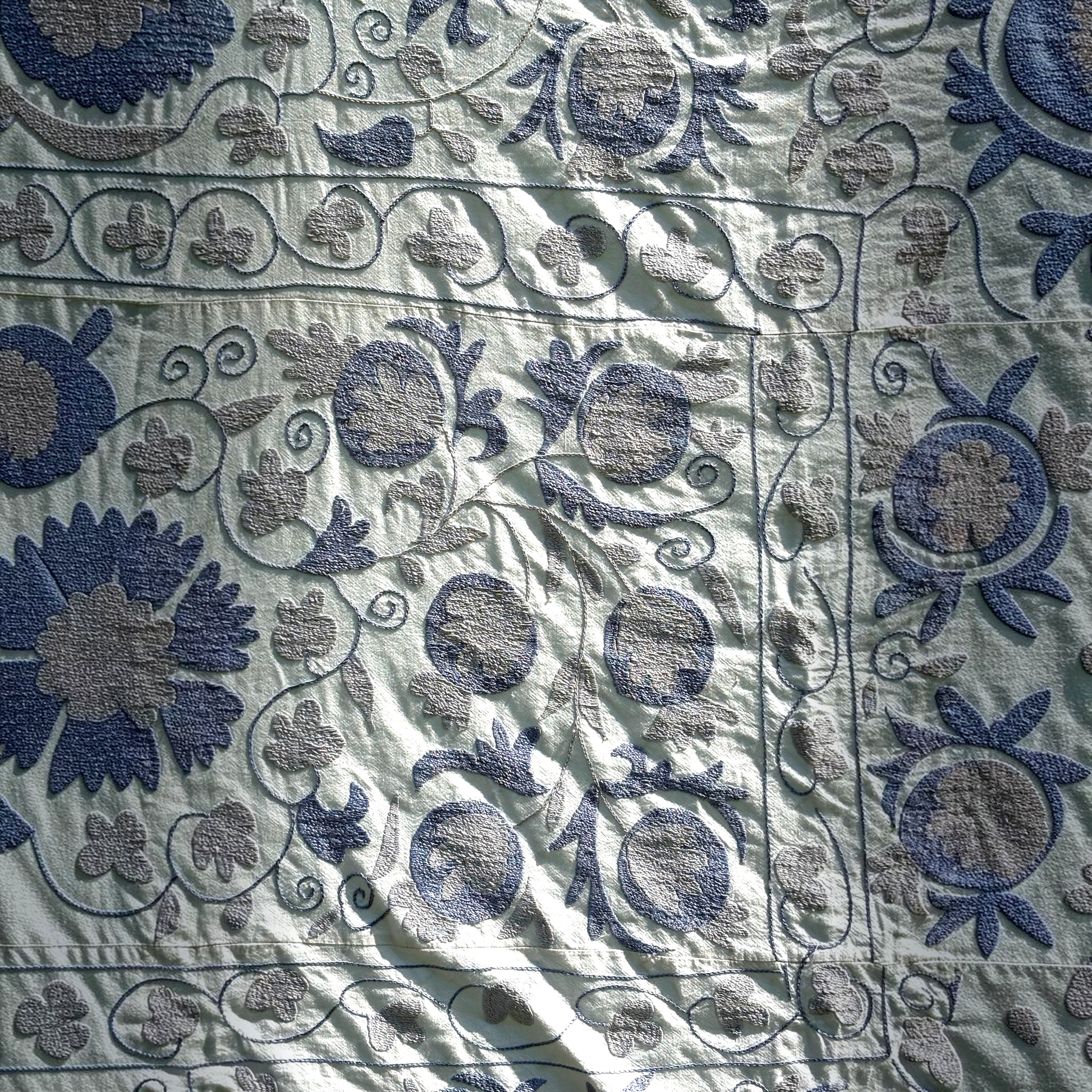 A closer look at the embroidery of the pale blue Suzani. 