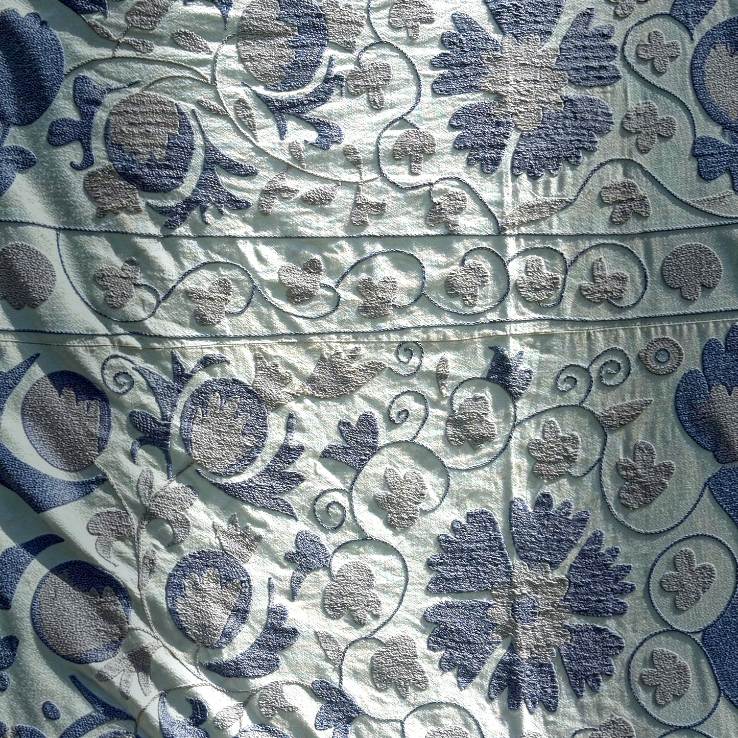 A close-up of the pale blue Suzani shown