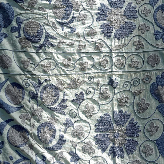 A close-up of the pale blue Suzani shown