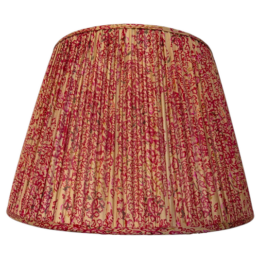 Raspberry & Champagne tapered gathered lampshade with a patterned trim at the base, shown on its own