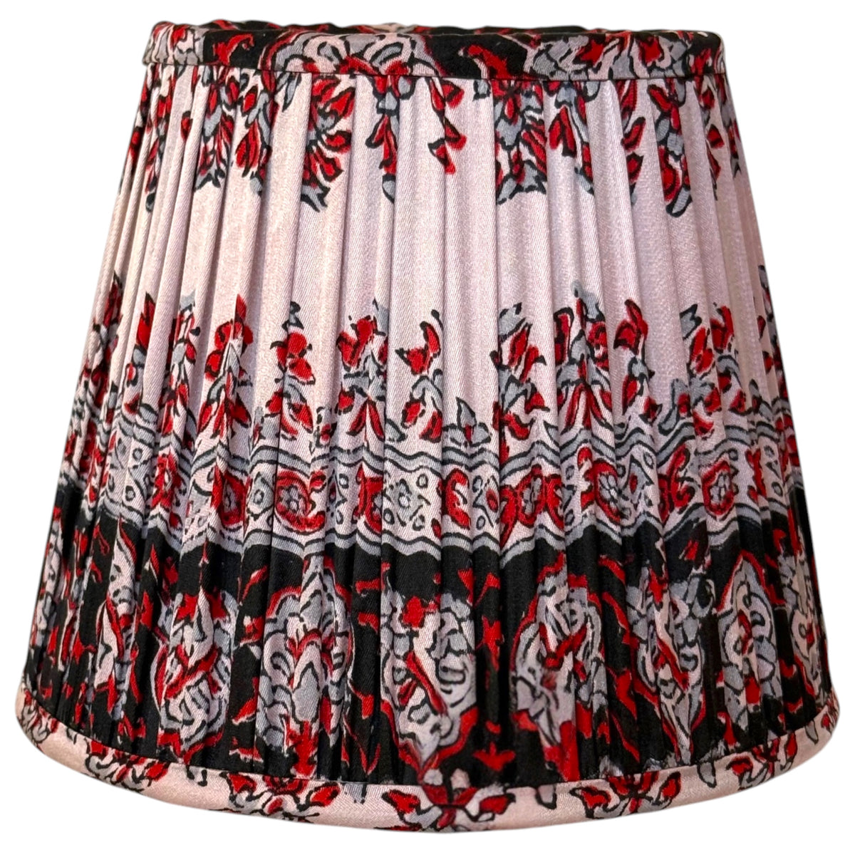 Small 15cm gathered silk sari lampshade with a red, grey and black floral block print on a blush pink ground and a deep black patterned border at the base.
