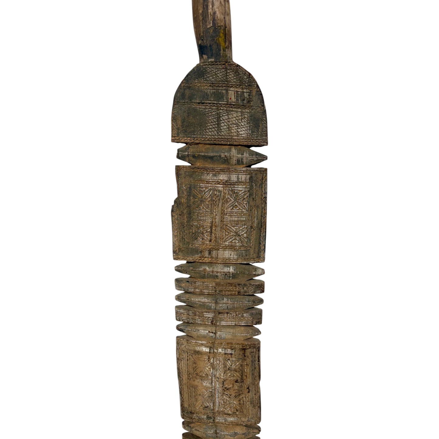 An intricately carved wooden decorative object with geometric patterns and a weathered, rustic finish, isolated on a white background.