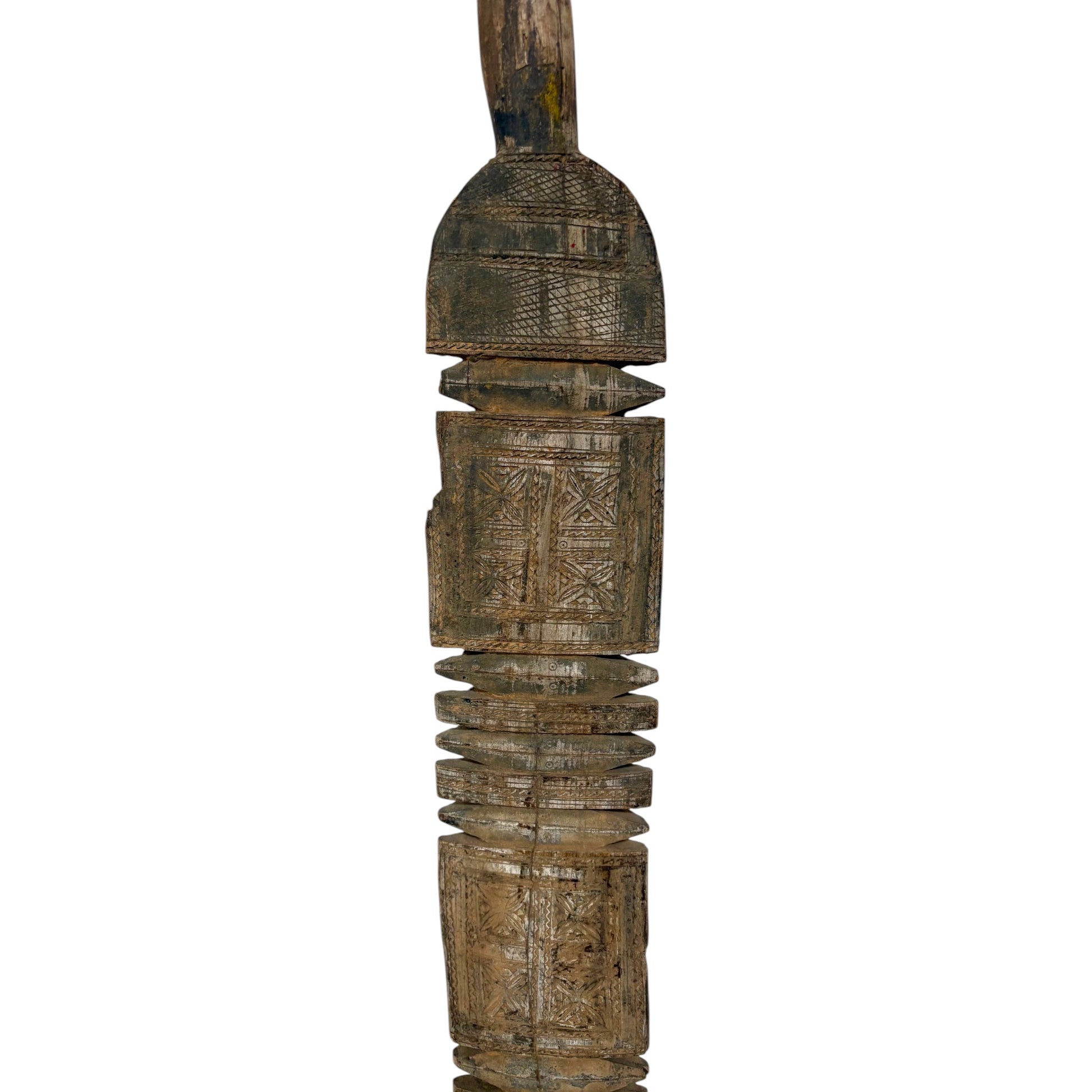 An intricately carved wooden decorative object with geometric patterns and a weathered, rustic finish, isolated on a white background.