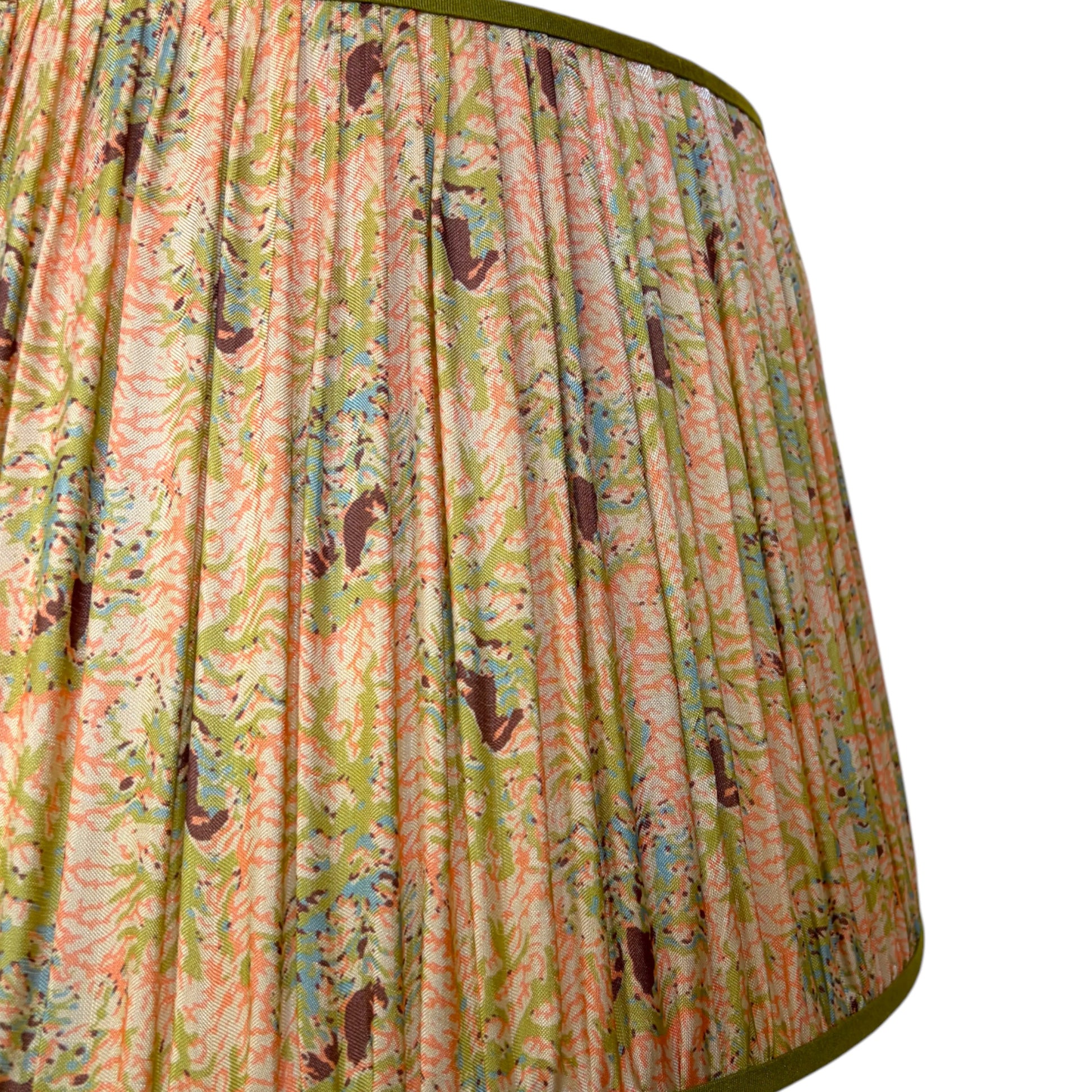 Close-up of hand-gathered silk pleats showing coral and seaweed pattern detail and olive trim binding