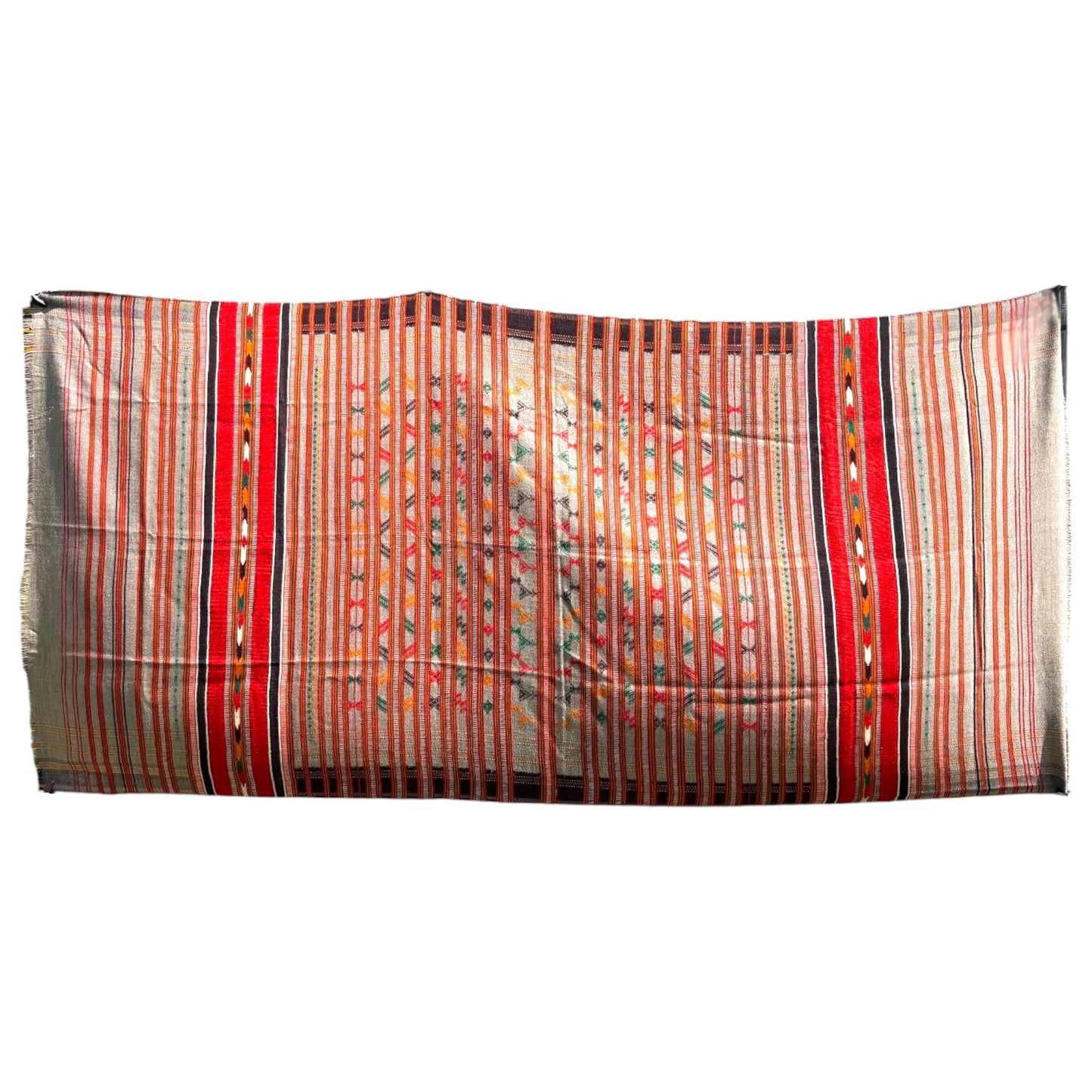 A rectangular woven textile with vertical striped patterns in red, orange, beige, and black, featuring geometric motifs and fringed edges, shown against a plain white background.