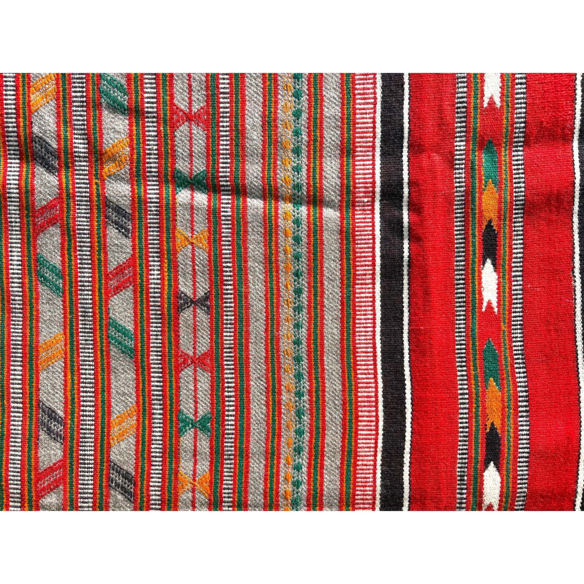 A close-up of a woven textile with vertical stripes and geometric patterns in red, gray, black, green, orange, and white.