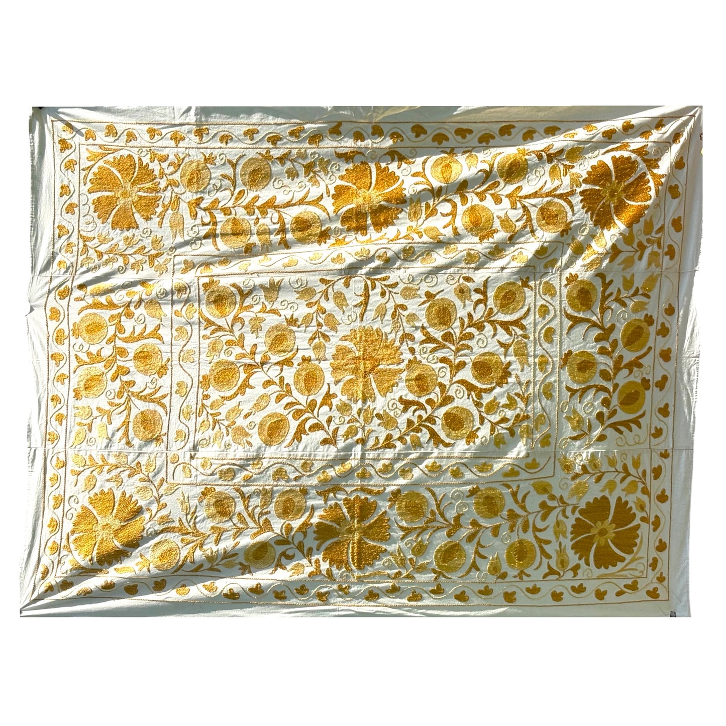 A Suzani featuring an intricate golden-yellow floral and vine pattern. 