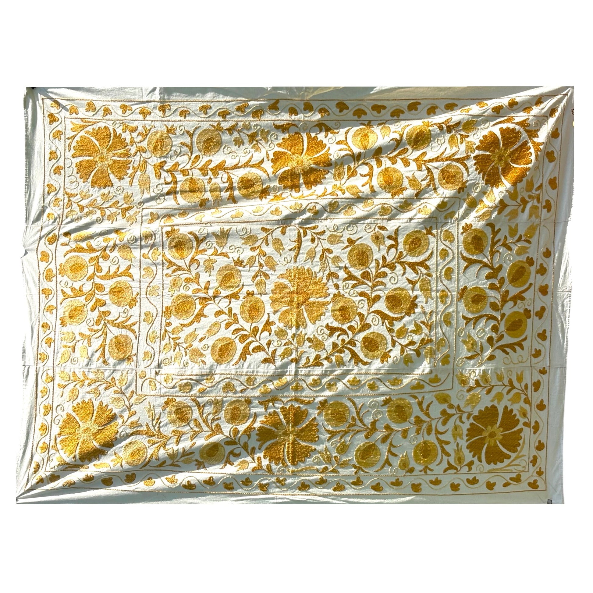 A Suzani featuring an intricate golden-yellow floral and vine pattern. 