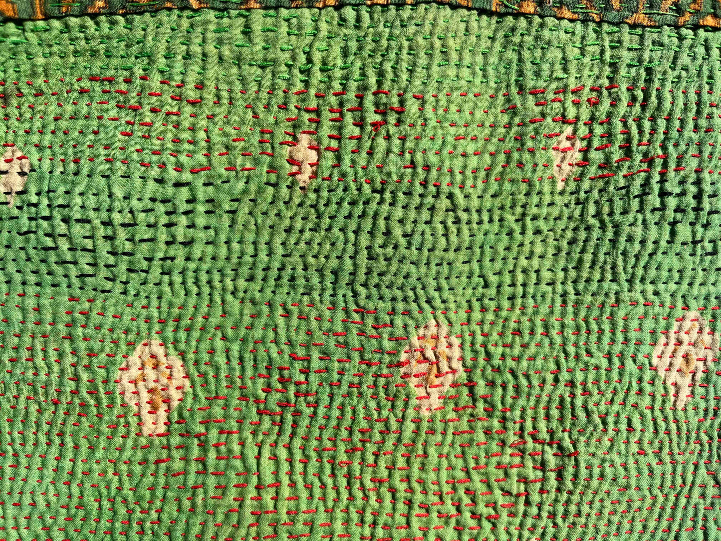 Bright green kantha quilt close up