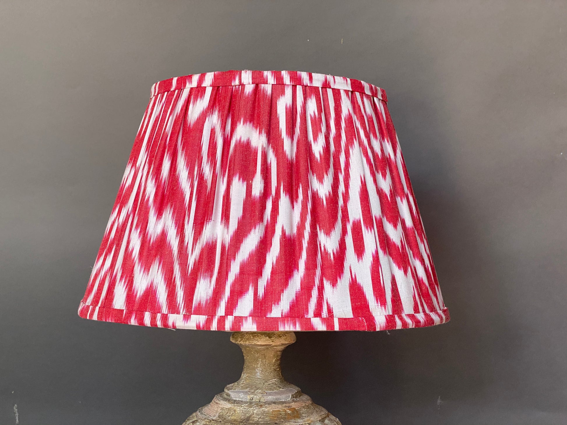 Red and white ikat silk lampshade on a grey background