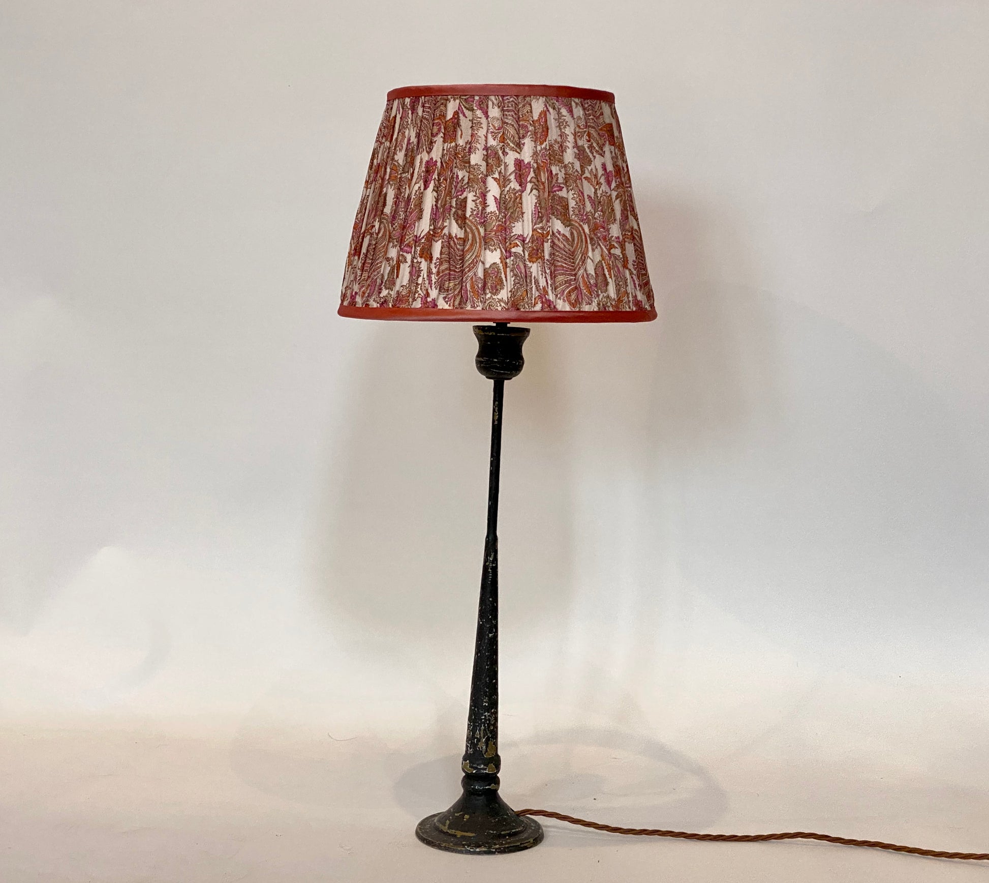 Pink and coral paisley silk sari lampshade shown on a candlestick table lamp