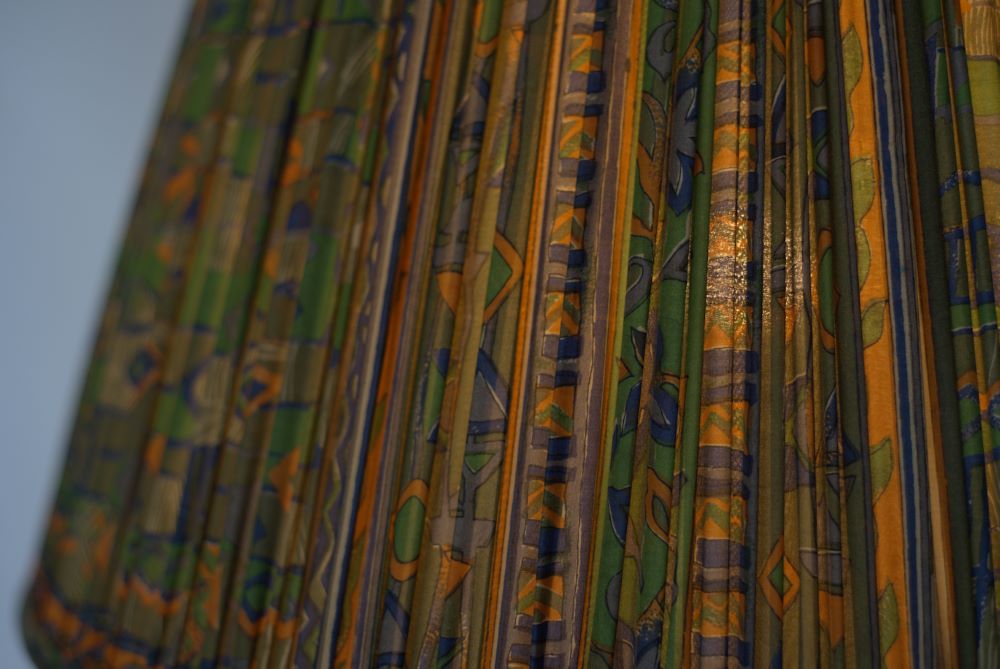 Green blue and orange abstract silk lampshade close up shown lit